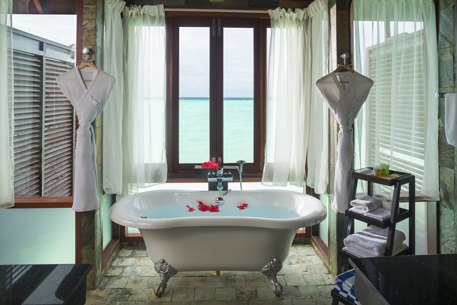 Freestanding bathtub with views over the Indian Ocean in a Jacuzzi Water Villa at luxury resort Sun Siyam Olhuveli in the Maldives