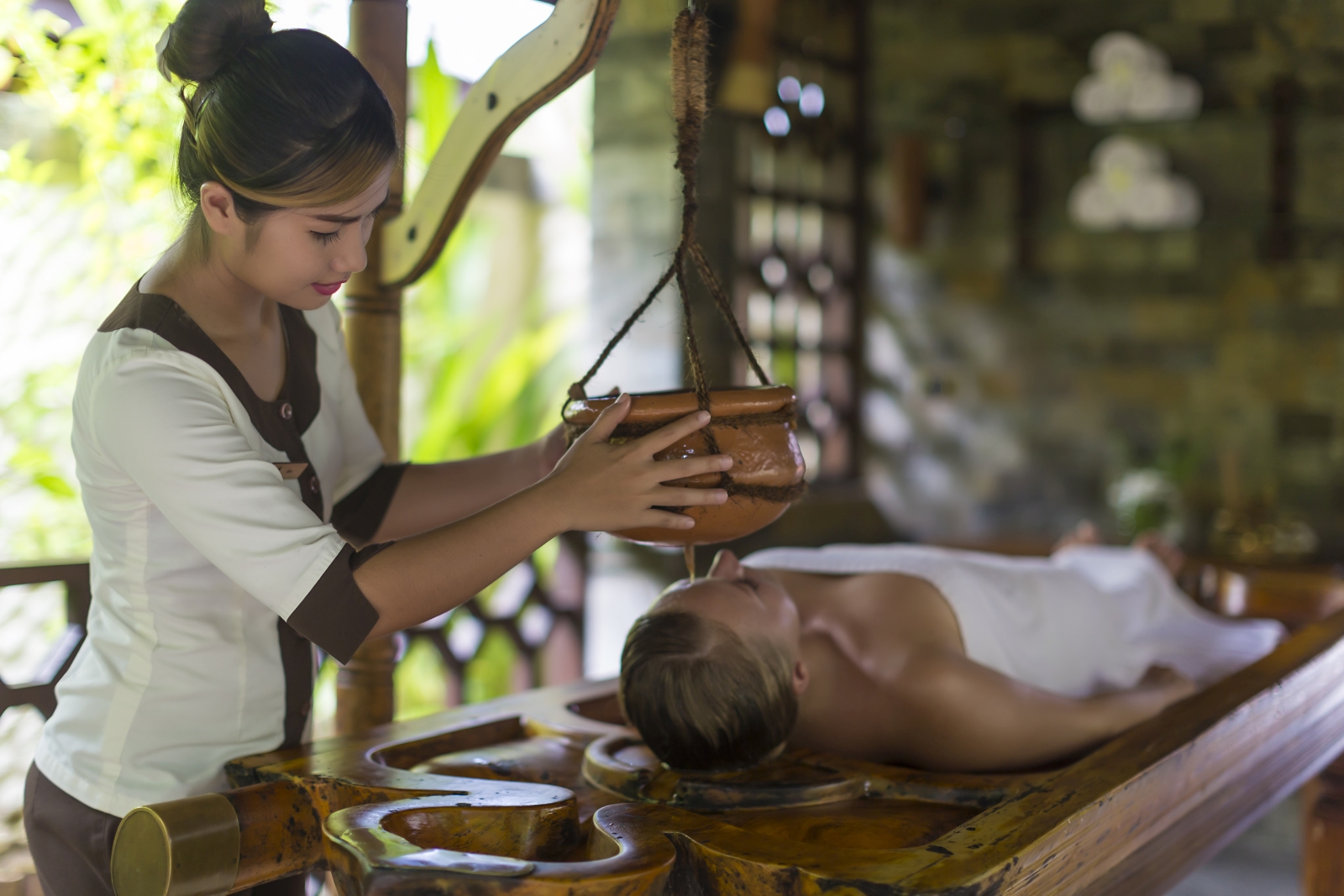 Woman enjoying a Spa treatment at luxury resort Sun Siyam Olhuveli in the Maldives