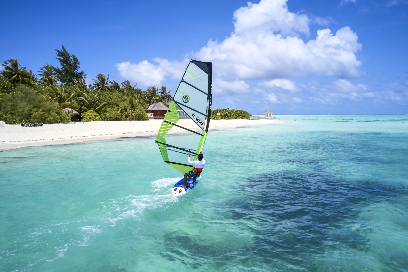 Man windsurfing at luxury resort Sun Siyam Olhuveli in the Maldives
