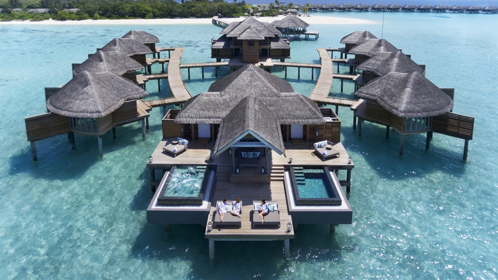 The Merana spa huts overwater with daybeds and pools from an aerial view