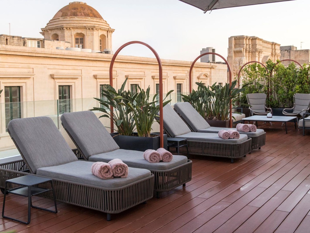 Loungers on the roof terrace at the Rosselli AX Privilege Hotel in Valletta Malta