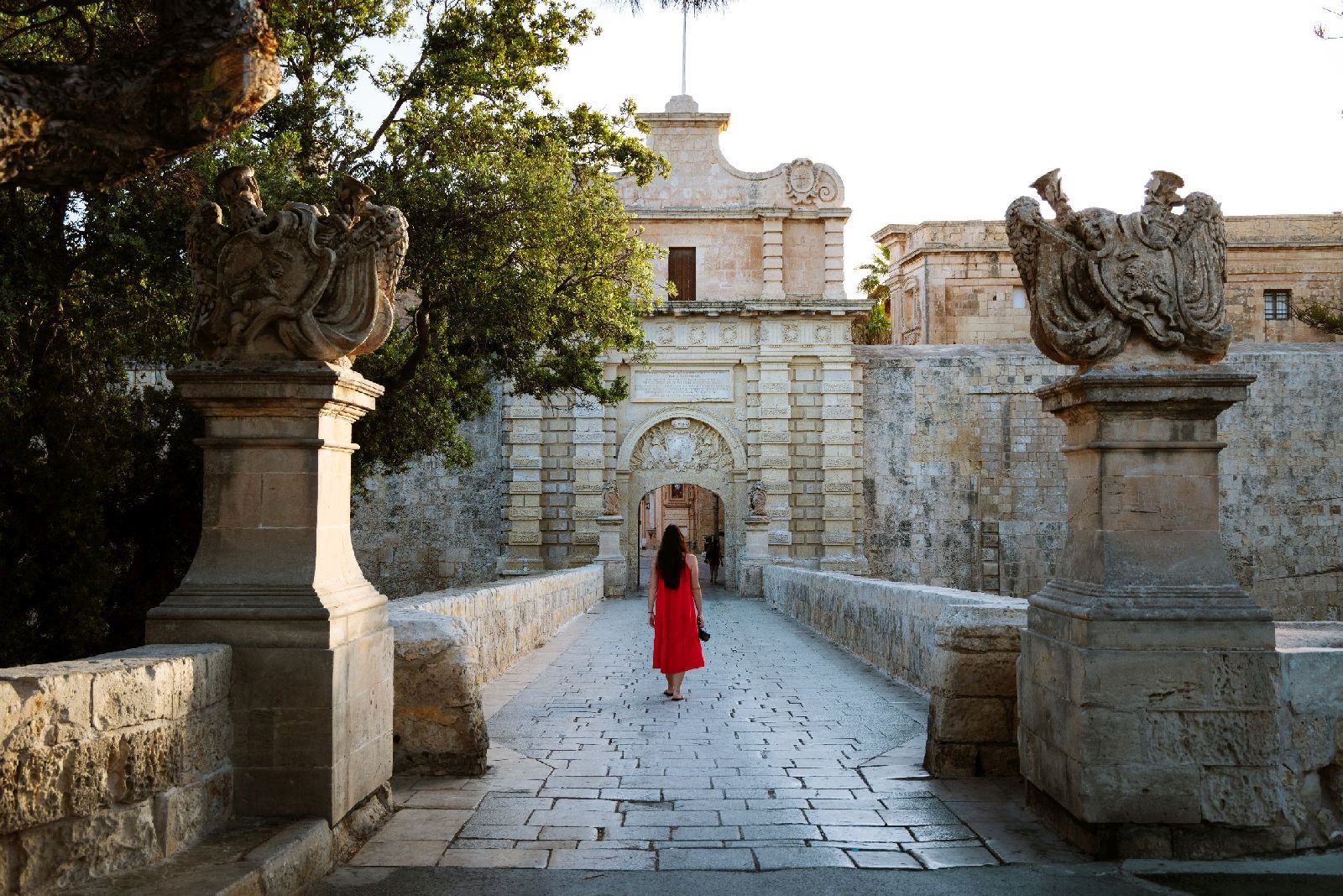 Lady entering the gates to the historic city of Mdina in Malta