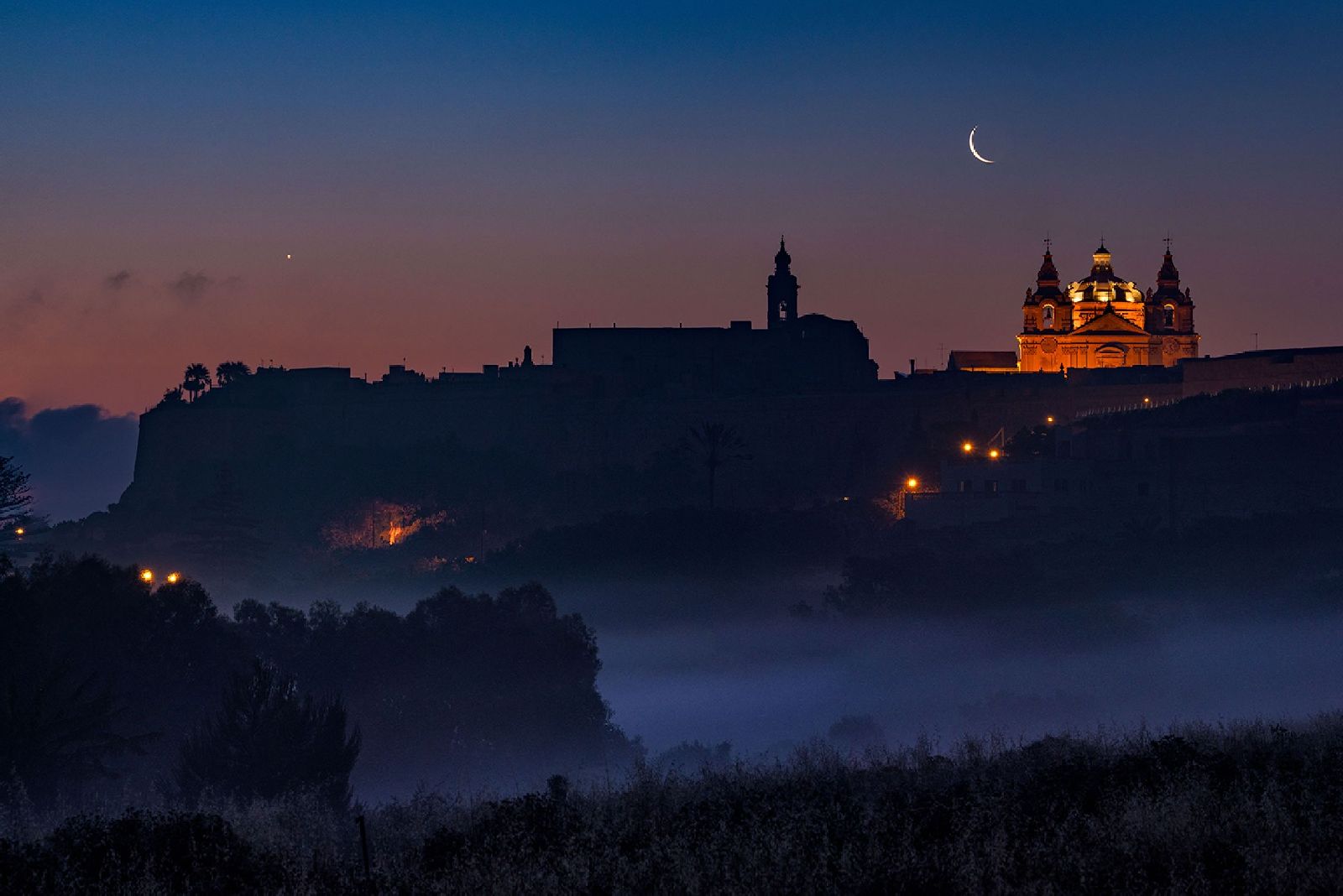 Distant view of the ancient city of Mdina in Malta illuminated by night