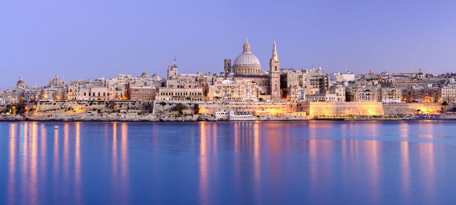 Panorama of Valletta city and coastline in Malta illuminated at dusk