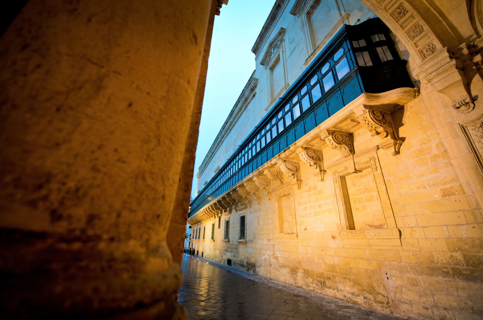 A narrow street and traditional wooden balconies in Valletta, Malta