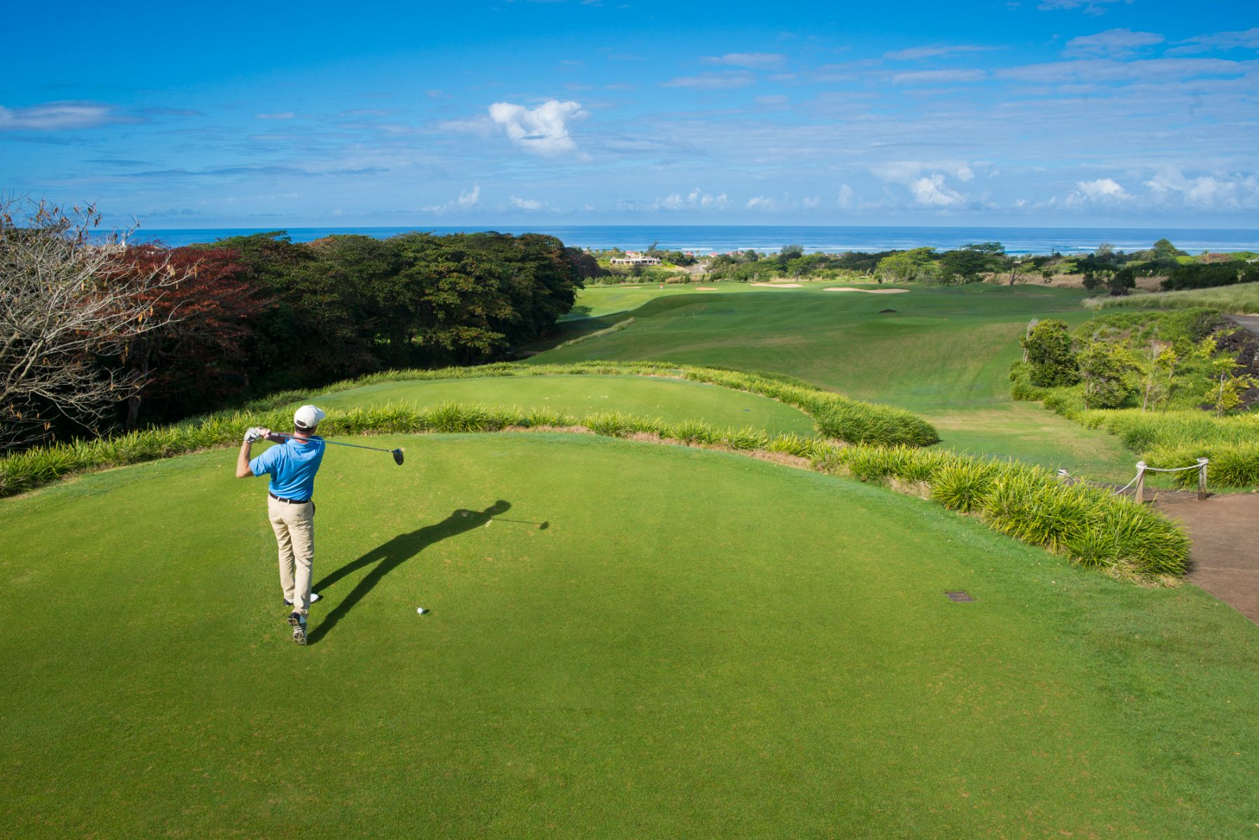 A man golfing on the course at Heritage Le Telfair Golf & Wellness Resort in Mauritius