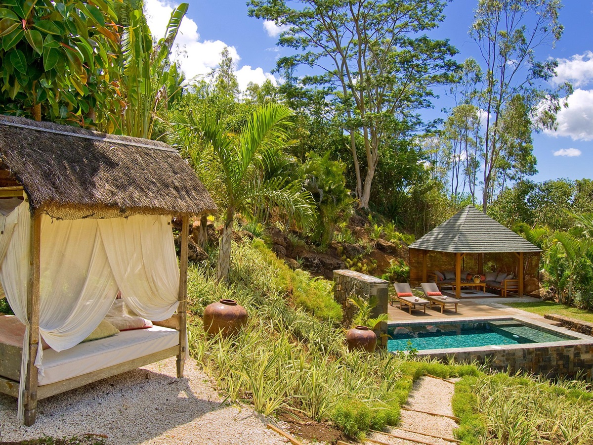 Sun lounger with swimming pool in the background of Lakaz Chamarel, Mauritius
