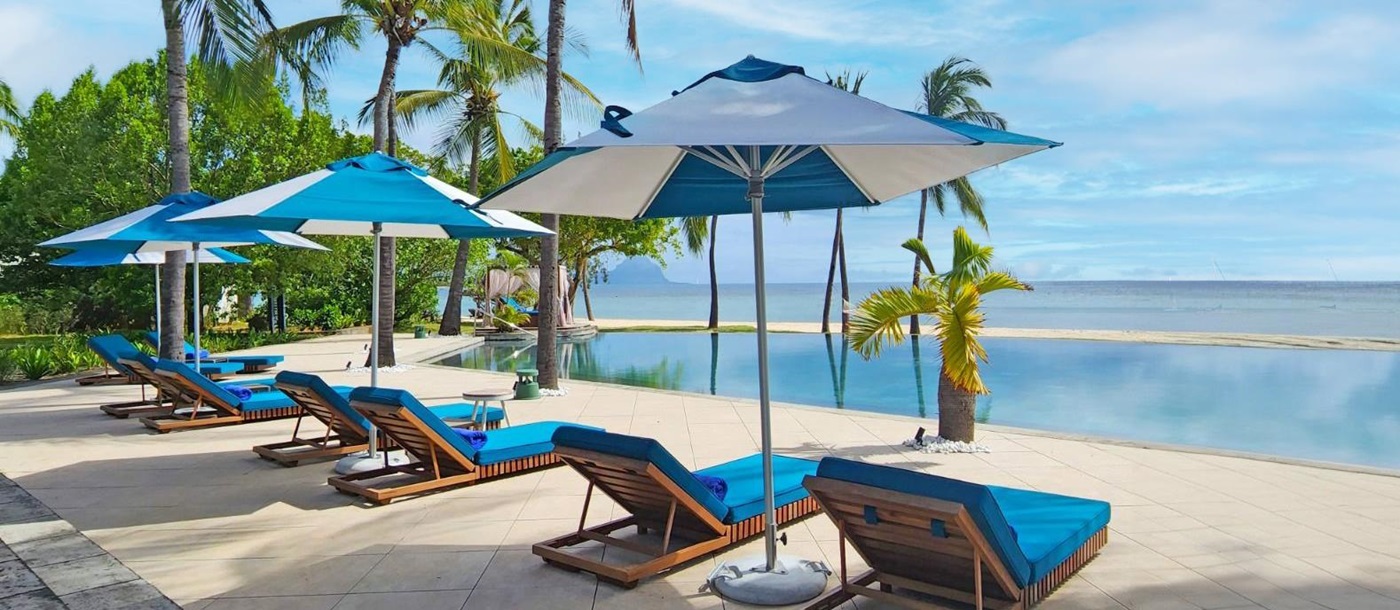 Sunbeds at the poolside overlooking the ocean at Maradiva Villa Resort and Spa