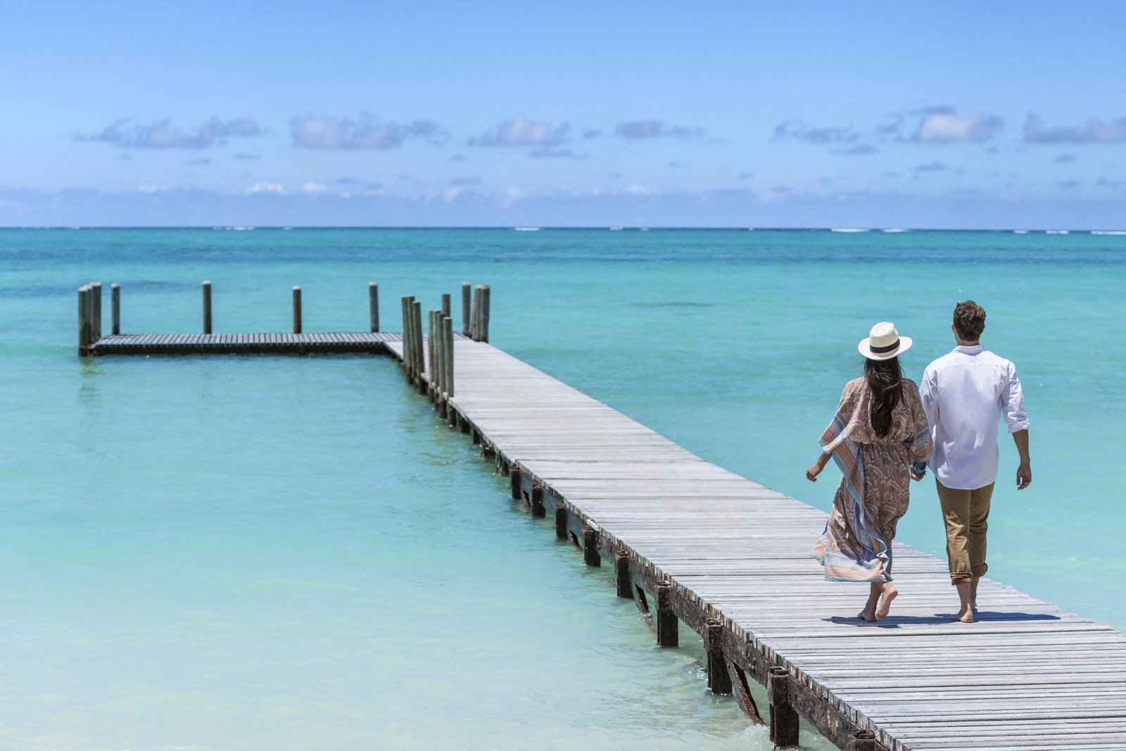 Couple walking over a jetty at Shangri La Le Touessrok, Mauritius