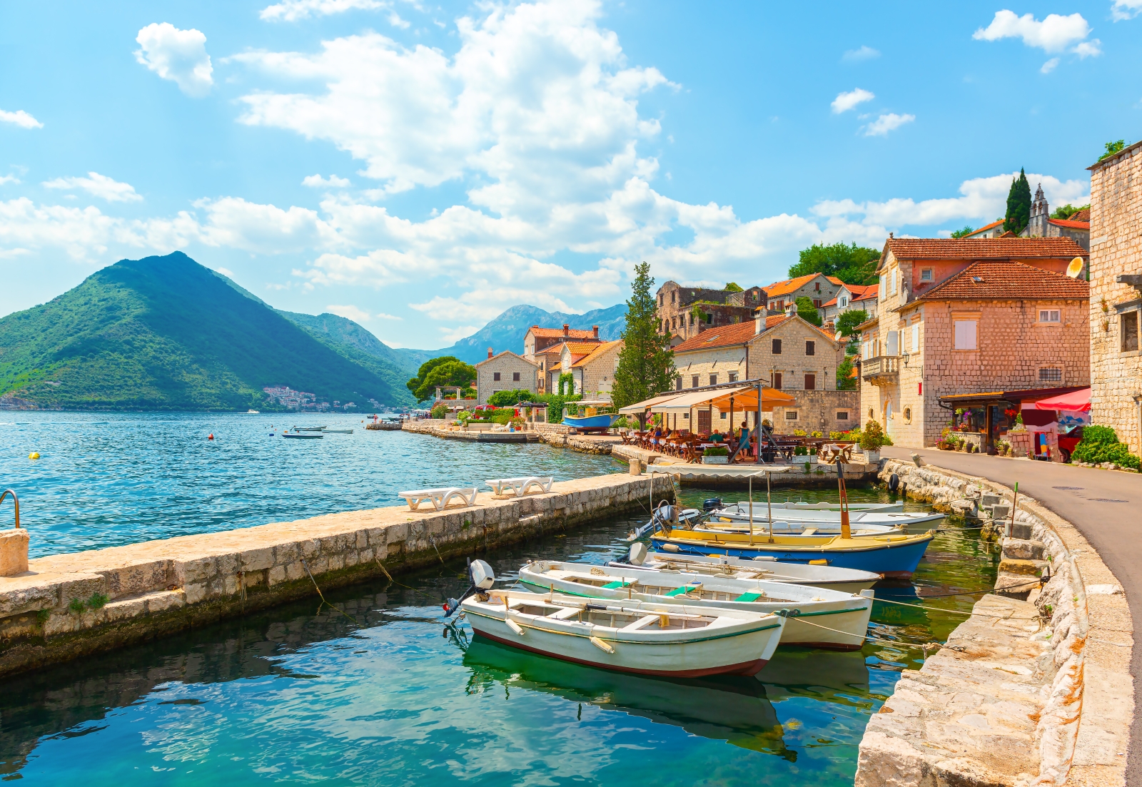 View of Perast Bay with mountains, houses and fishing boats