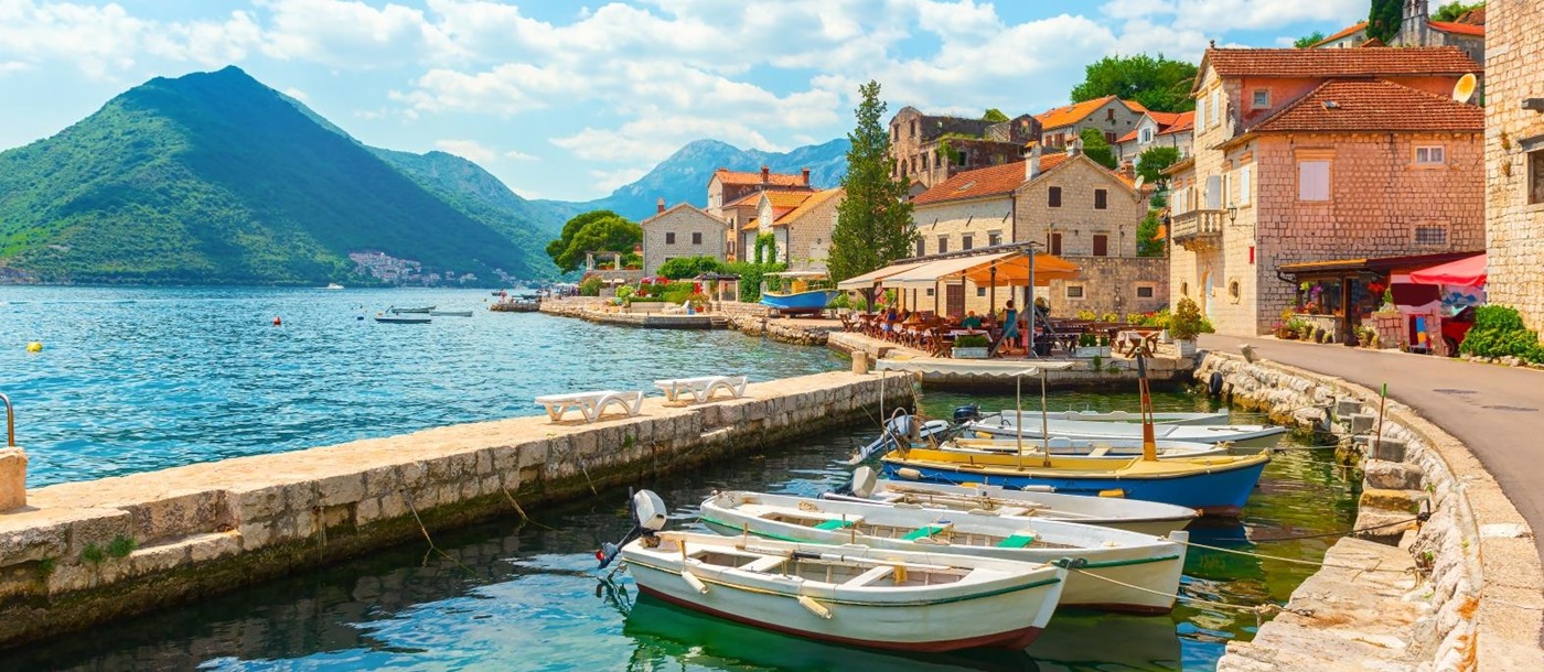 View of Perast Bay with mountains, houses and fishing boats