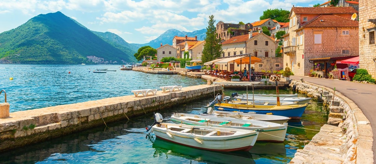 View of Perast Bay with mountains, houses and fishing boats