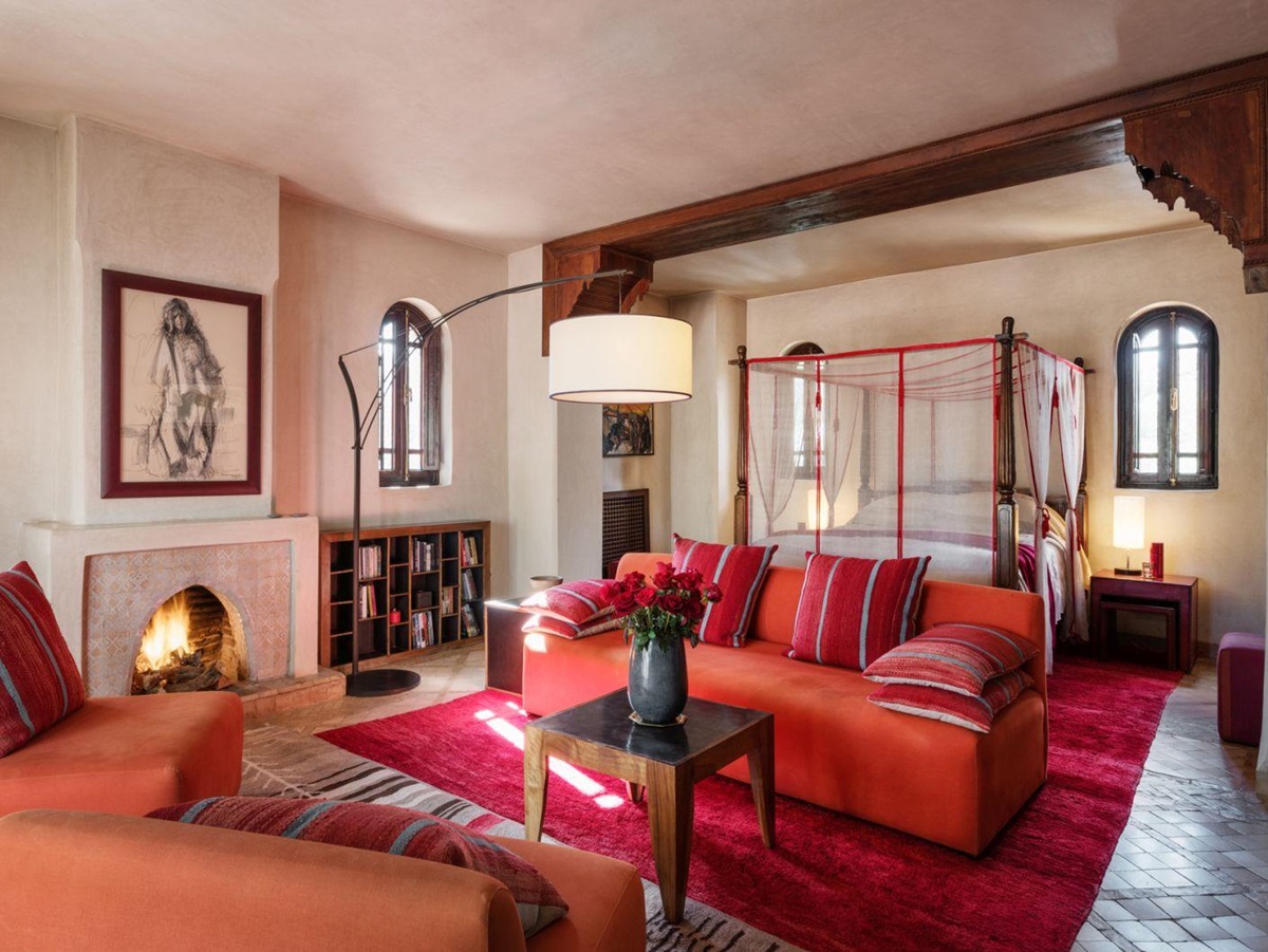 The Perla Suite with four poster bed, sofa, chairs and an open fire at Dar Zemora in Morocco