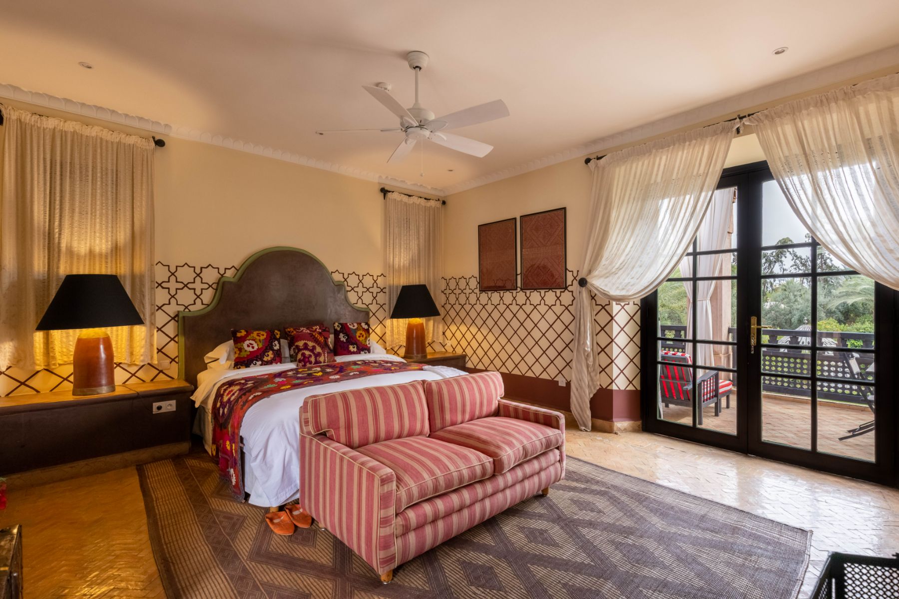 Double bedroom with red stripe sofa and window at Villa Ezzahra in Morocco