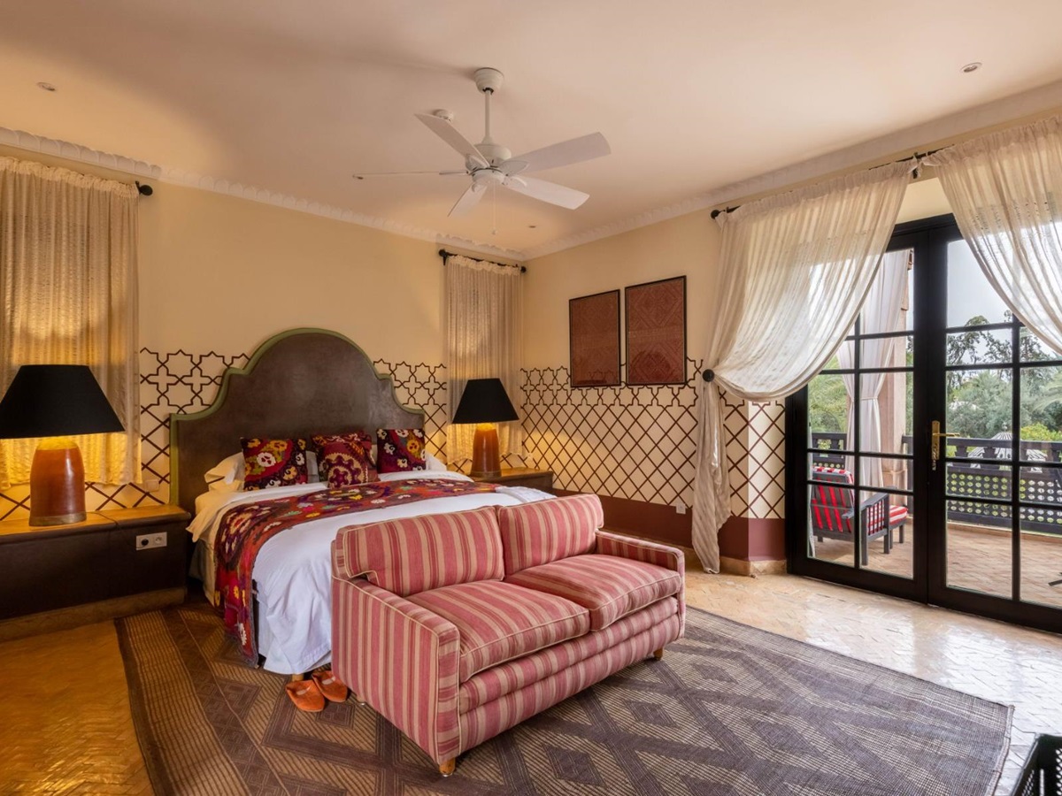 Double bedroom with red stripe sofa and window at Villa Ezzahra in Morocco