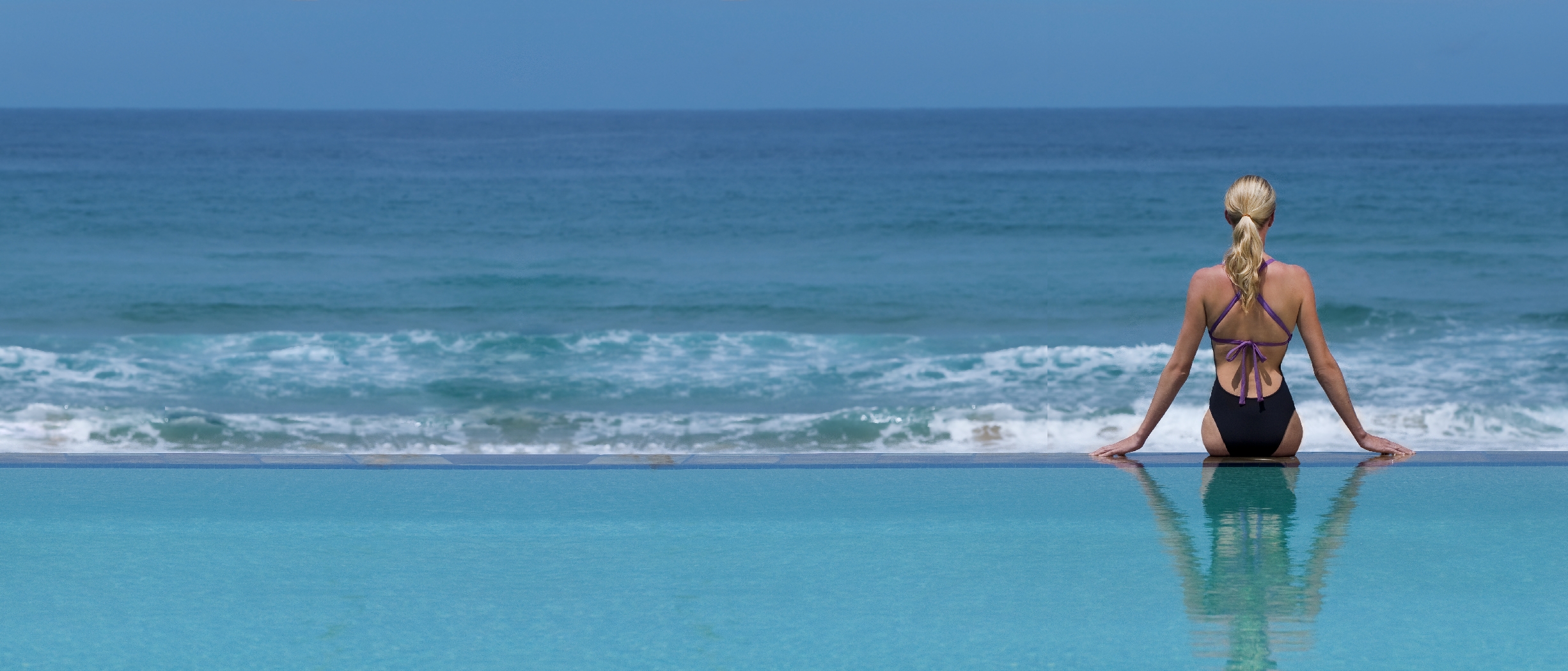 Reflection of a woman in the main pool of White Pearl, Mozambique