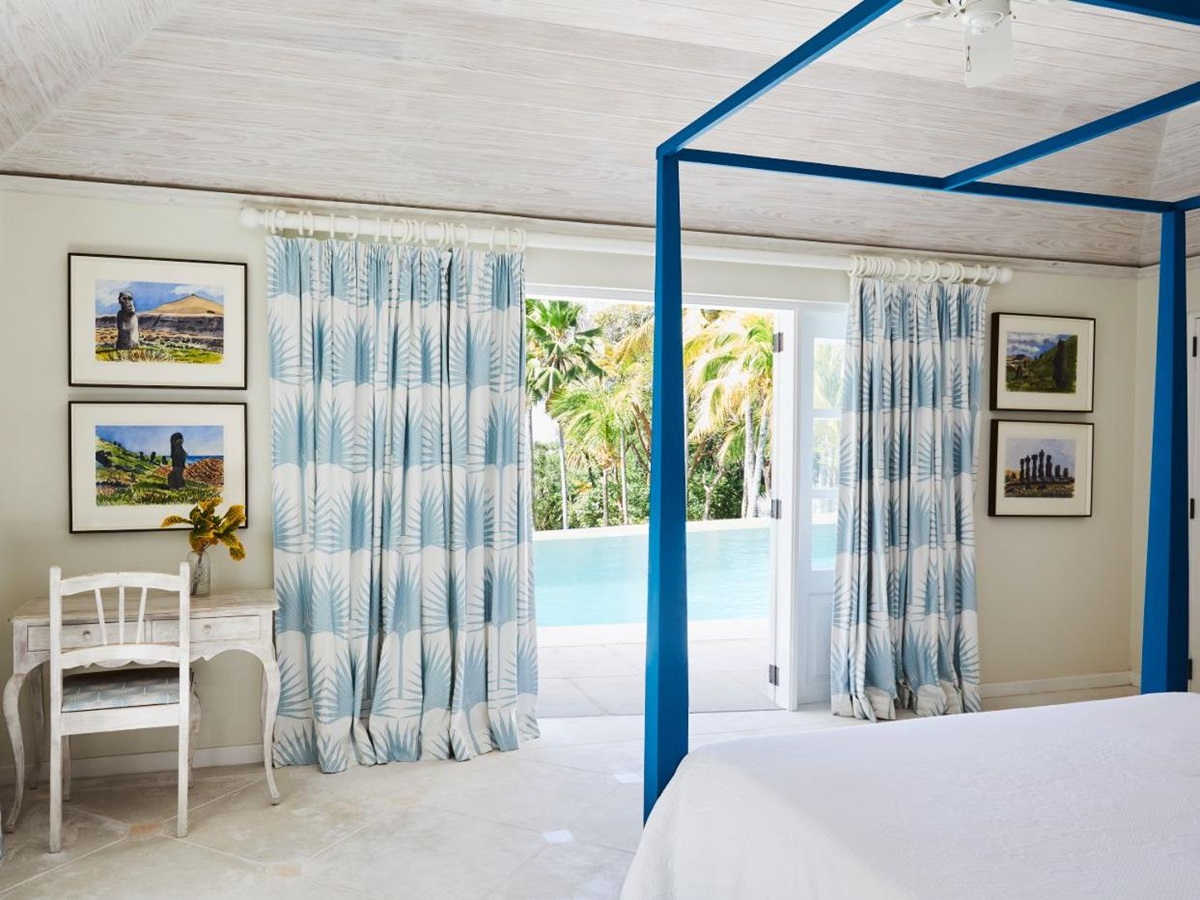 Bedroom at Bamboo House with four poster bed and view of the pool and gardens