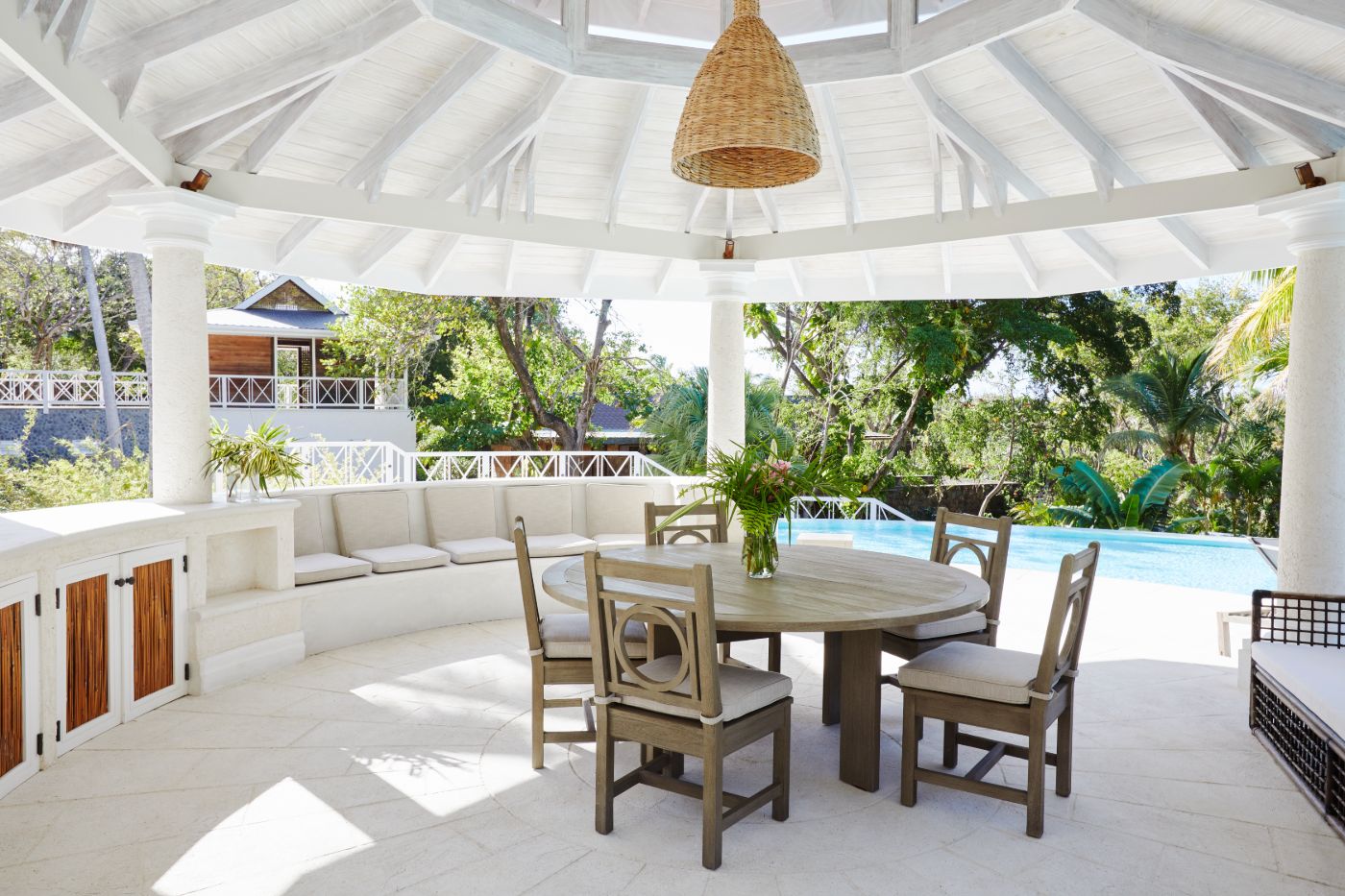 Outdoor dining area with views of the pool and gardens at Bamboo House