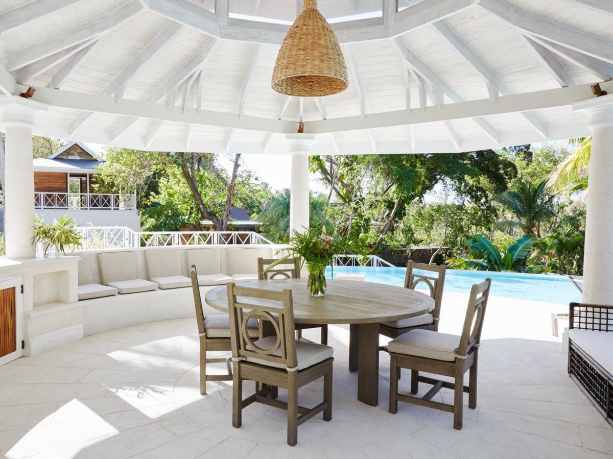 Outdoor dining area with views of the pool and gardens at Bamboo House