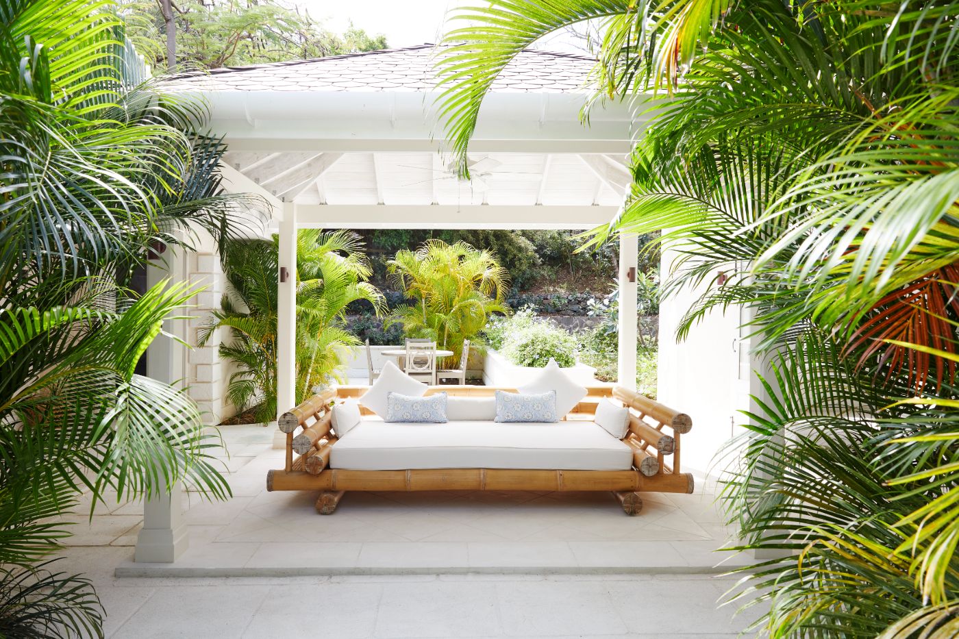 Covered terrace surrounded by bamboo and large lounge bed at Bamboo House