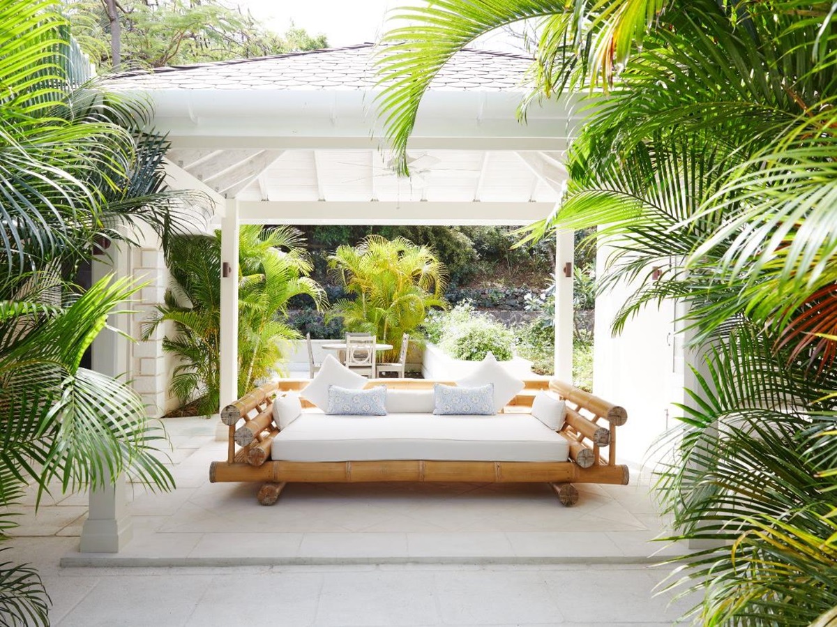 Covered terrace surrounded by bamboo and large lounge bed at Bamboo House