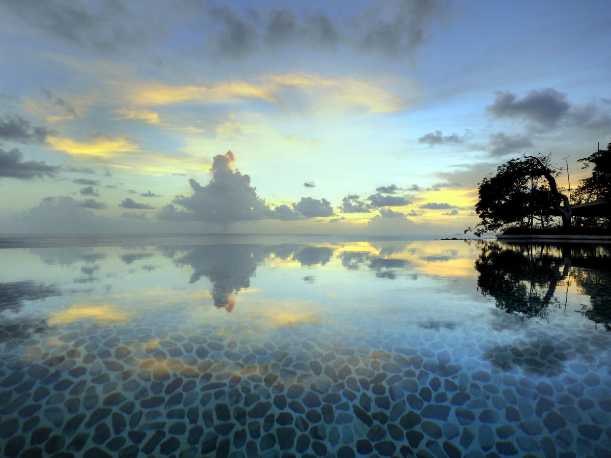 Evening view and reflectin into the swimming pool of Opium, Mustique