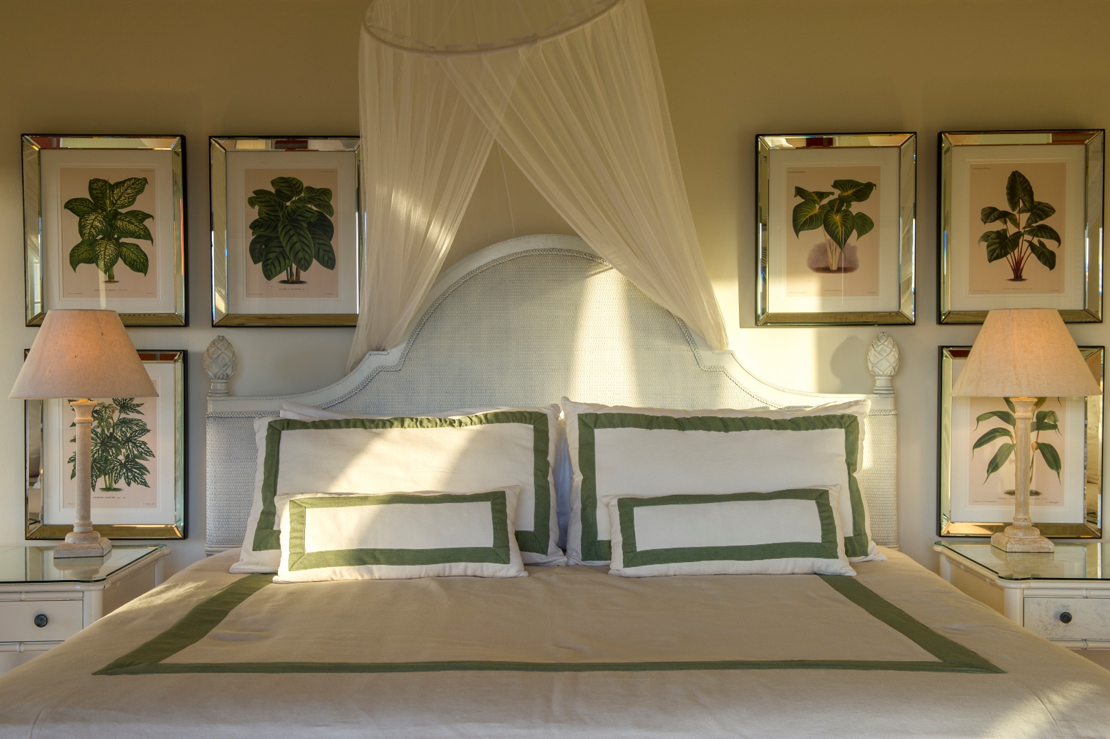 a double bedroom with lamps and botanic pictures at luxury villa Pangolin in Mustique