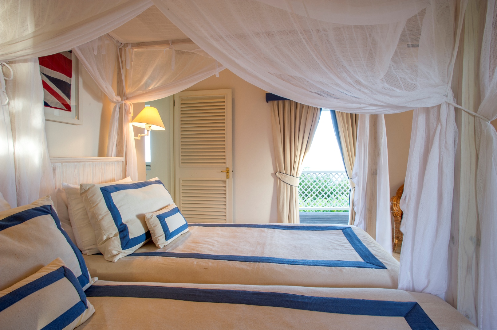 A twin bedroom with mosquito nets at luxury villa Pangolin in Mustique