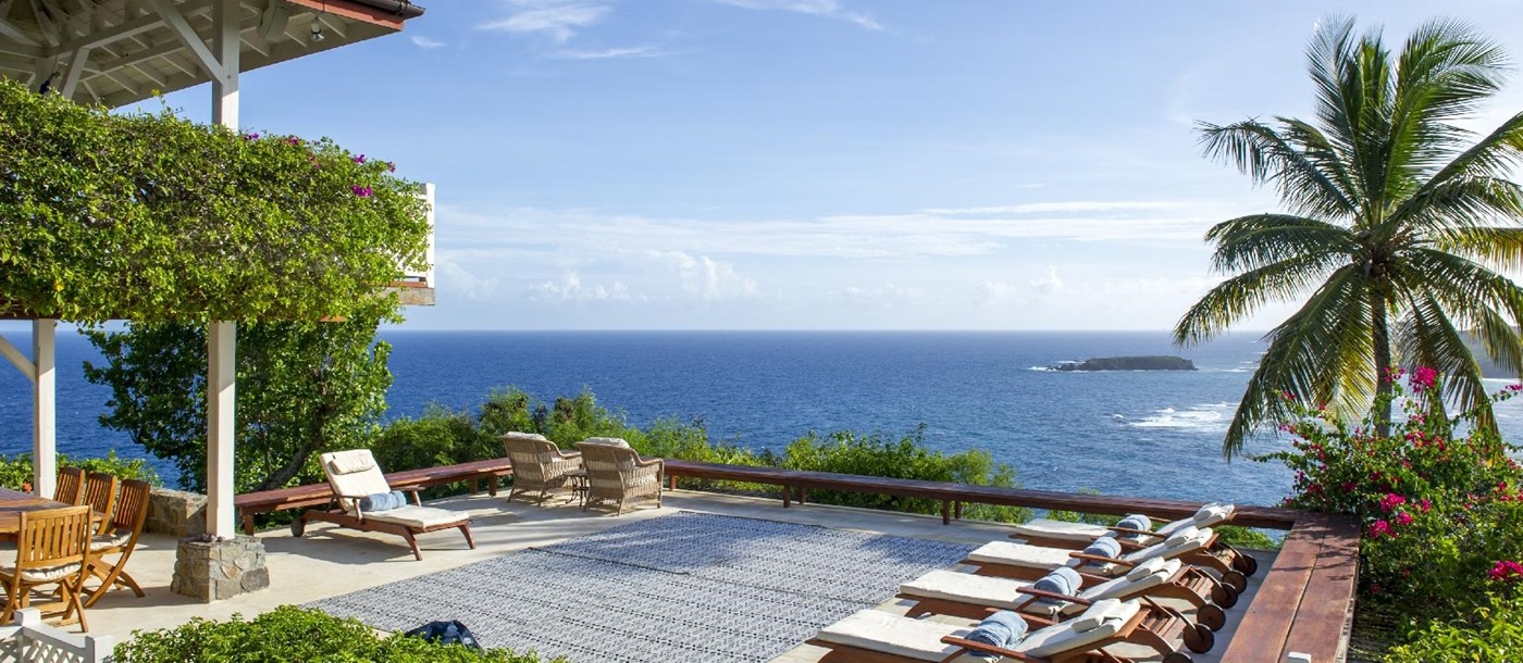 Terrace with sun loungers at plantation-style villa Pangolin in Mustique