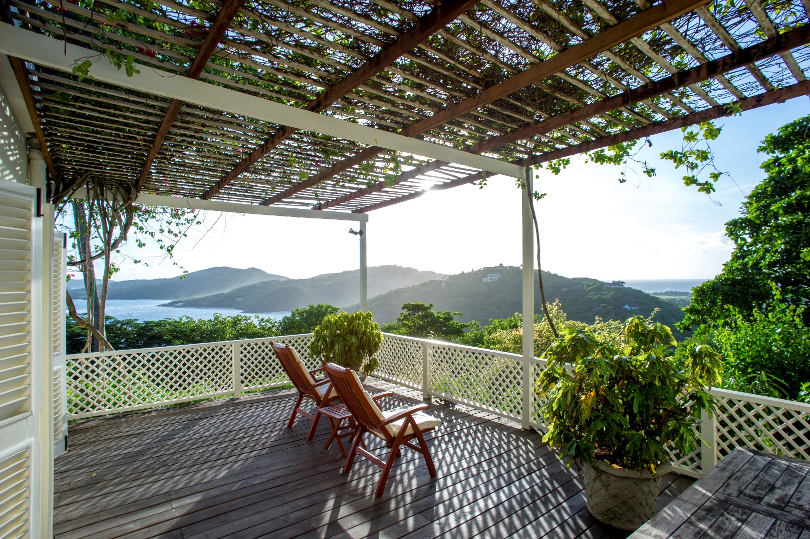 a terrace overlooking the surrounding green hills at villa Pangolin in Mustique