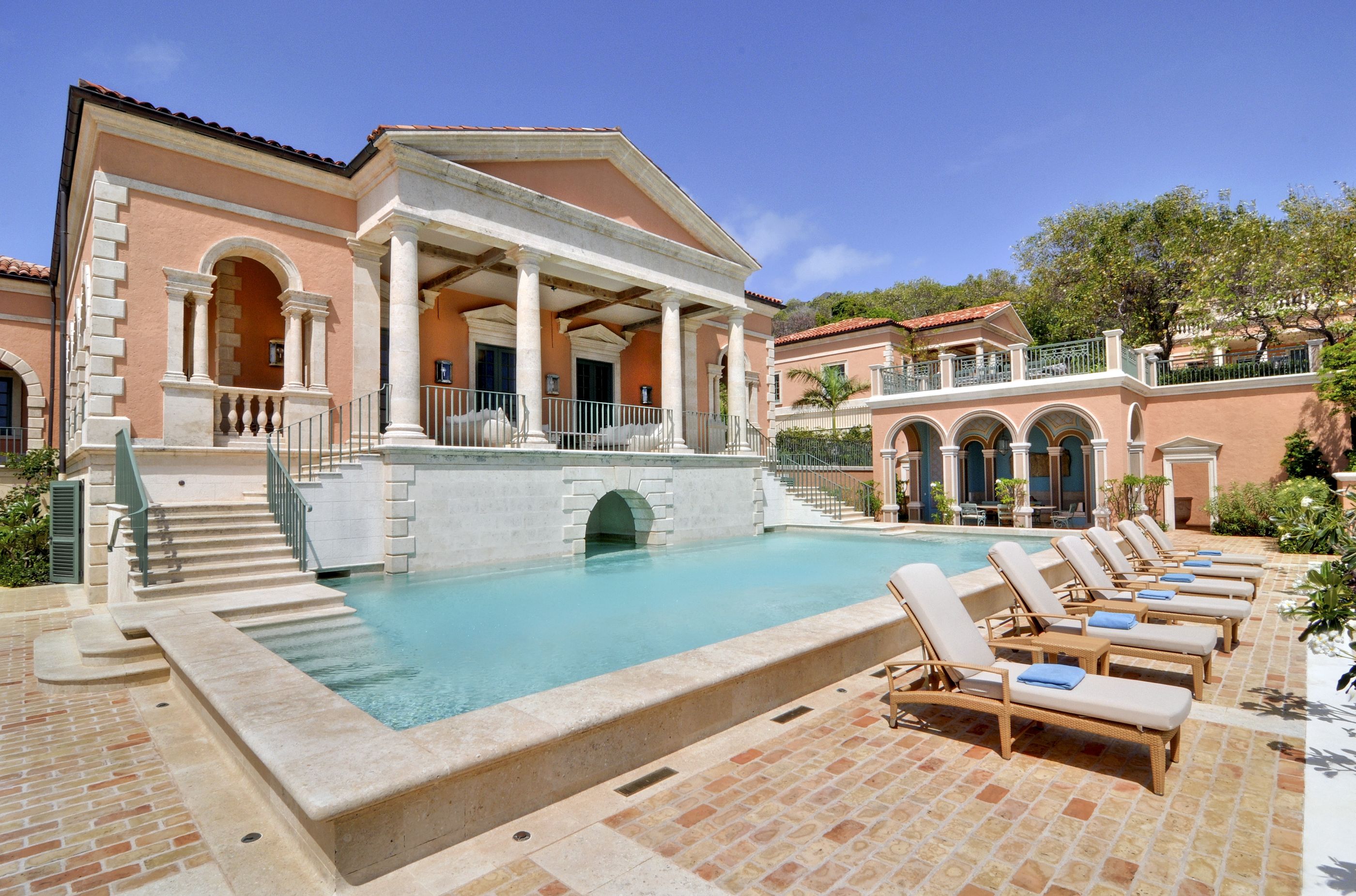 Sunbeds in front of the swimming pool and facade of Sienna, Mustique