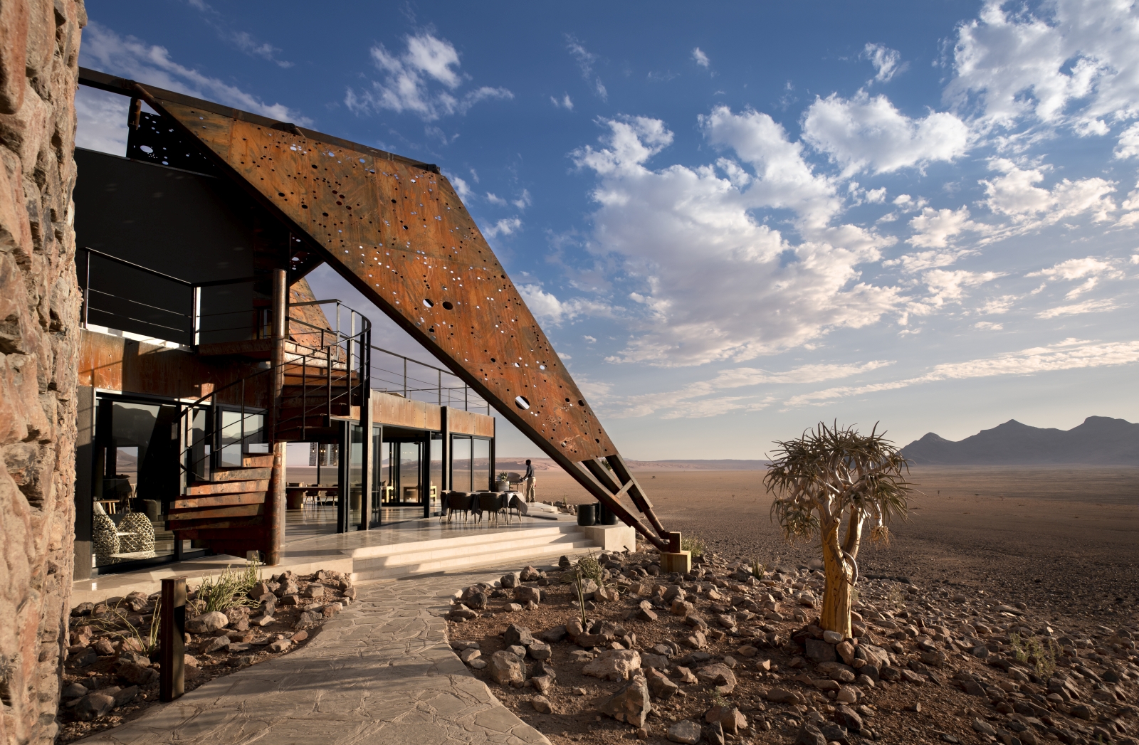Outdoor seating area, exterior of the main lodge and view over the desert