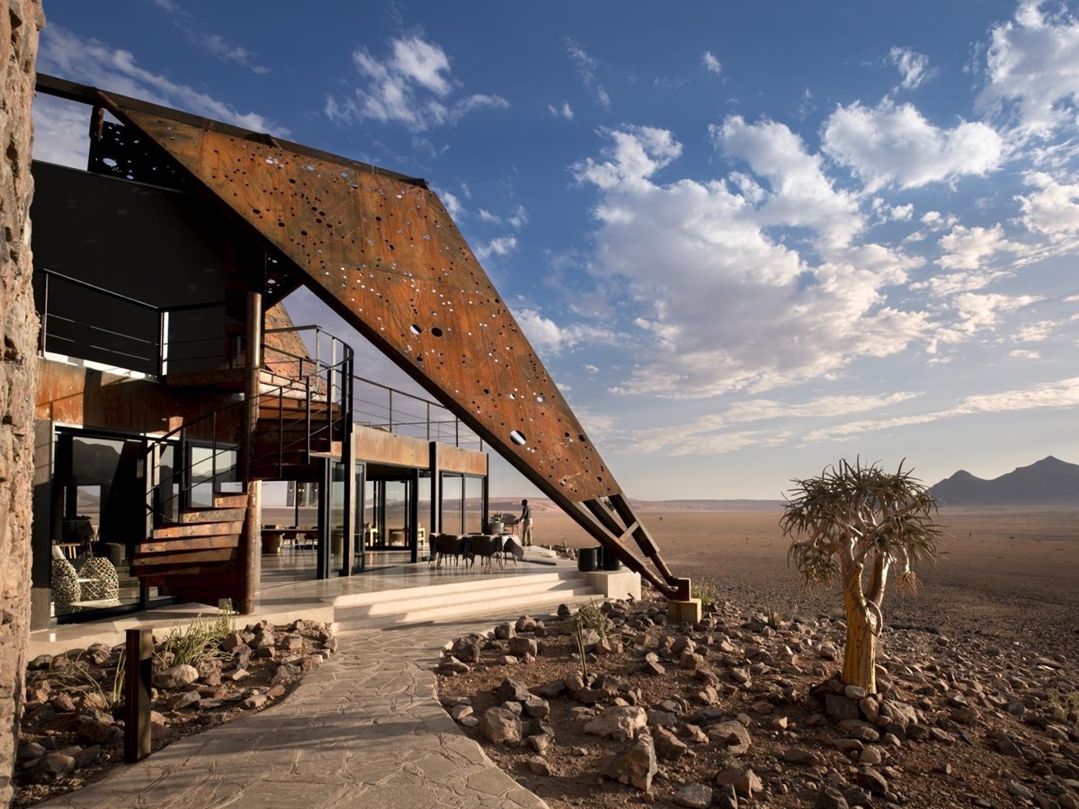 Outdoor seating area, exterior of the main lodge and view over the desert