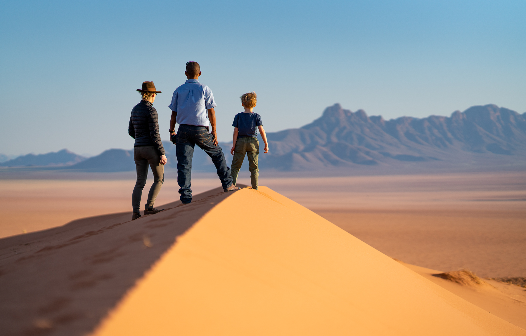 A family standing on a dune during a nature walk from Kwessi Dunes in Namibia