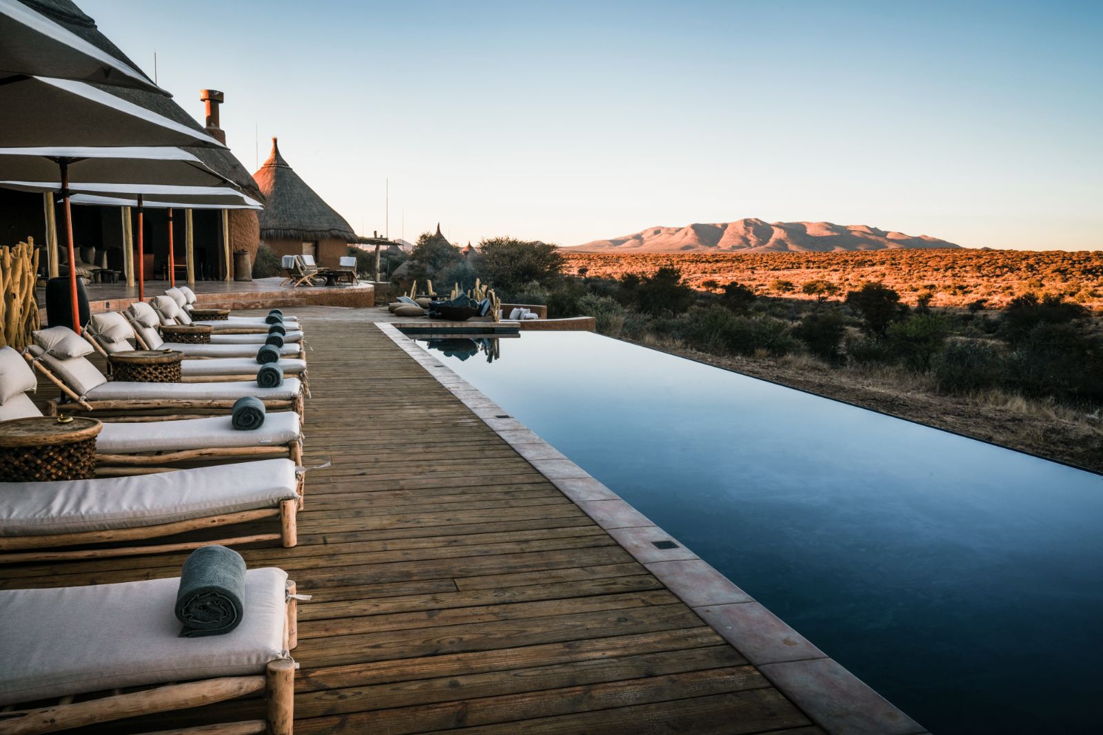 Sunlounges by the pool overlooking the stunning scenery at luxury hotel Omaanda by Zannier Hotels in Namibia