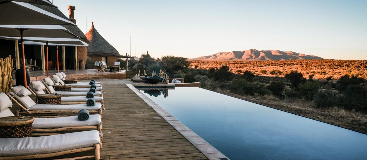 Sunlounges by the pool overlooking the stunning scenery at luxury hotel Omaanda by Zannier Hotels in Namibia