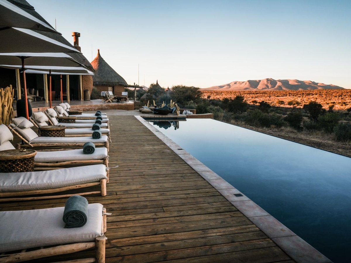 Sunlounges by the pool overlooking the stunning scenery at luxury hotel Omaanda by Zannier Hotels in Namibia