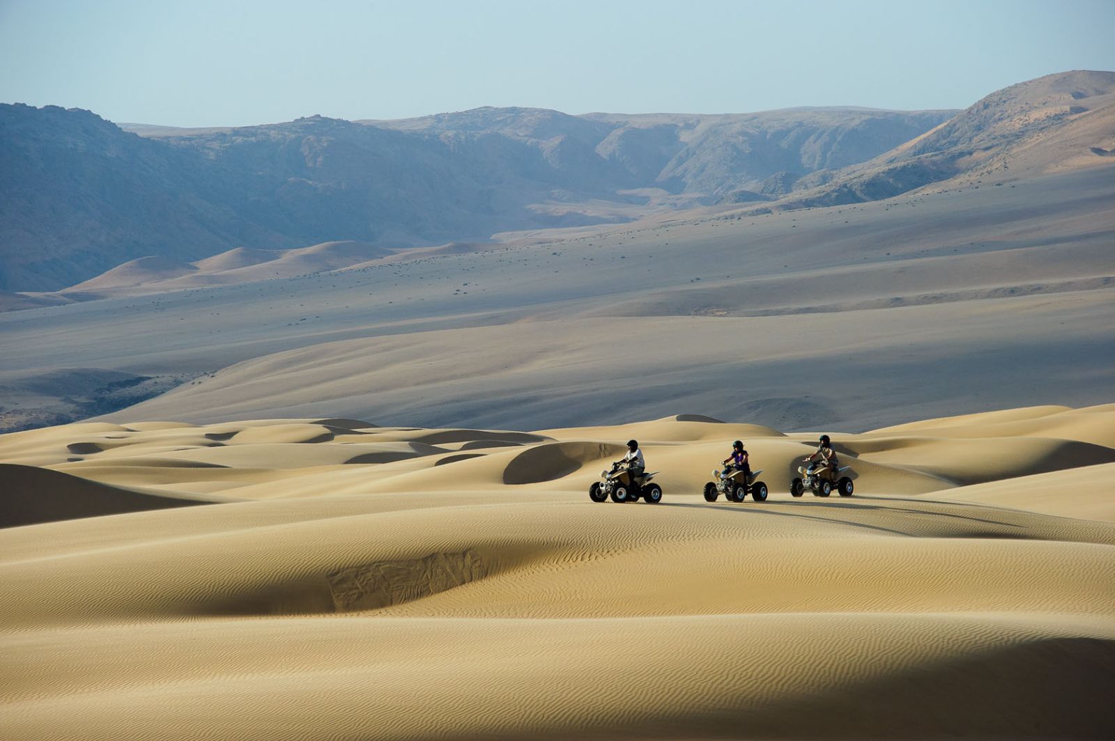  Guests exploring the dunes on a quad biking trip during a stay at luxury lodge Serra Cafema in Kakaoland, Namibia