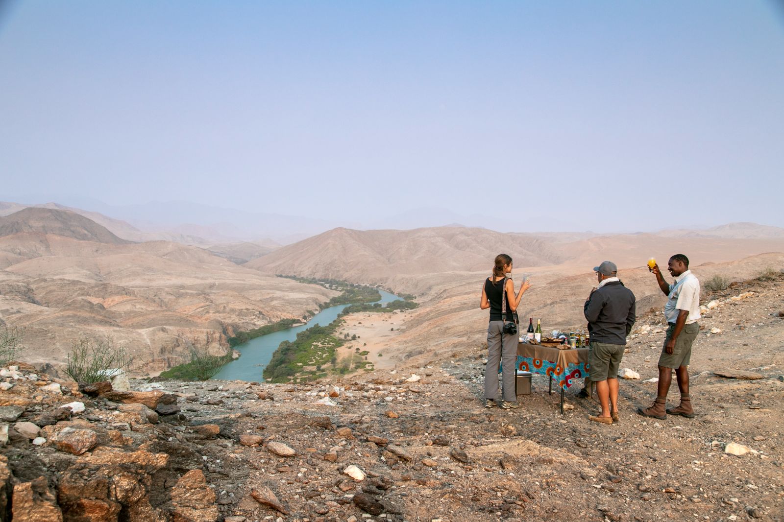 Guests enjoying a tea break overlooking the river during a stay at luxury lodge Serra Cafema in Kakaoland, Namibia