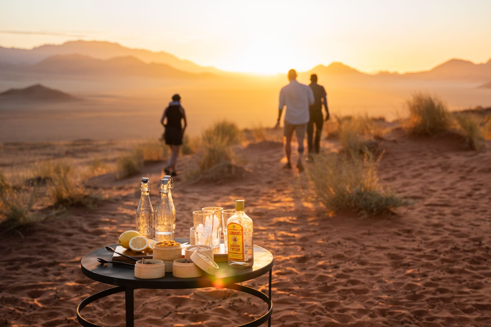 Guests on a sundowner stop in the NamibRand Nature Reserve during a stay at one of the luxury lodges of Wolwedans in Namibia