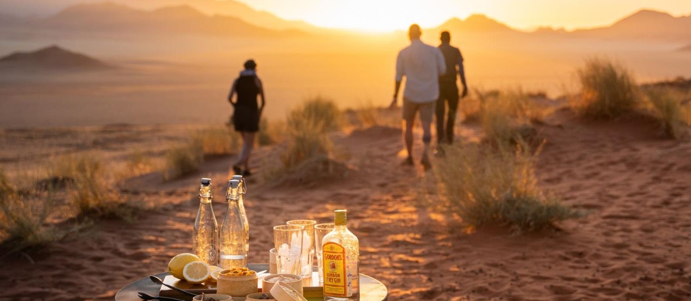 Guests on a sundowner stop in the NamibRand Nature Reserve during a stay at one of the luxury lodges of Wolwedans in Namibia