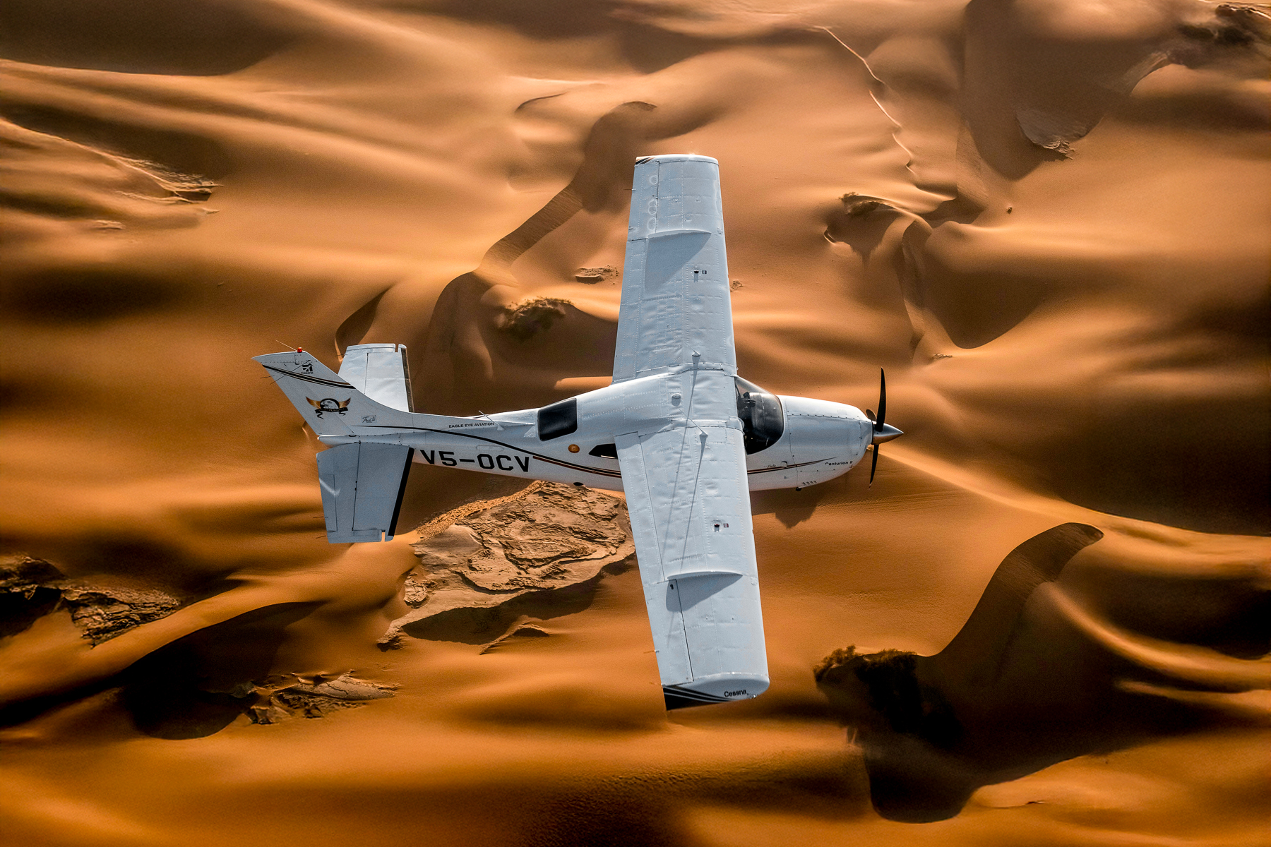 A plane flying over the sand dunes of Namibia