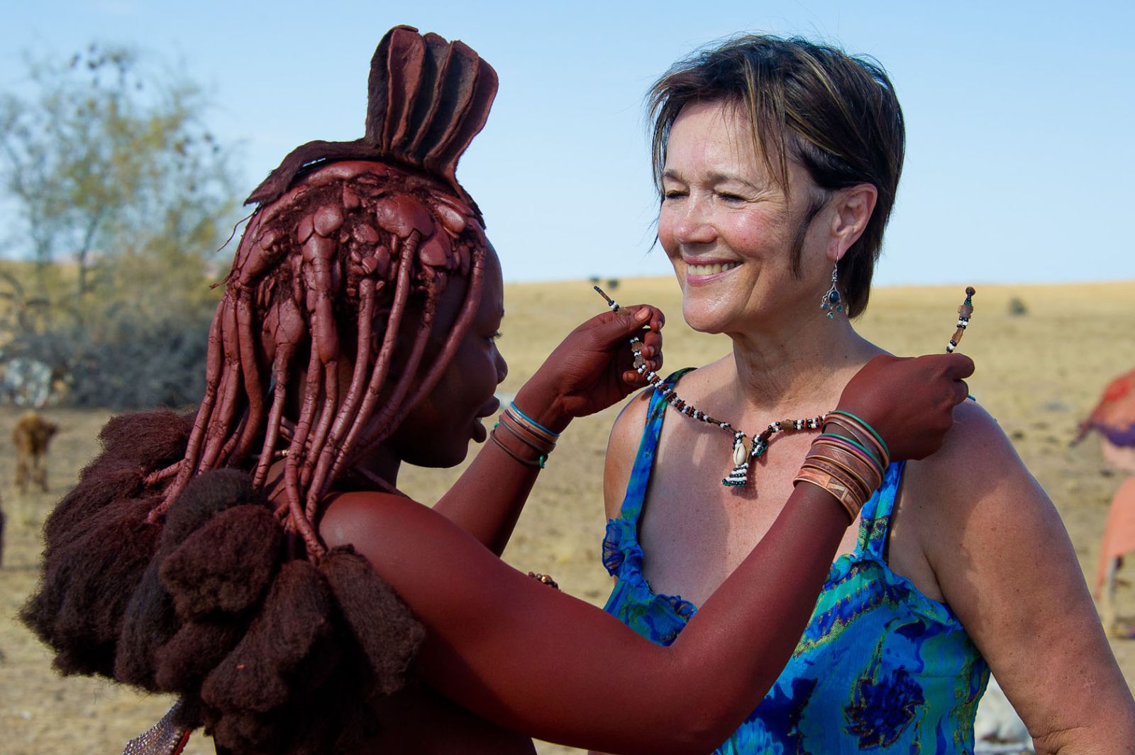 Woman purchasing a necklace from a local Himba woman in Namibia