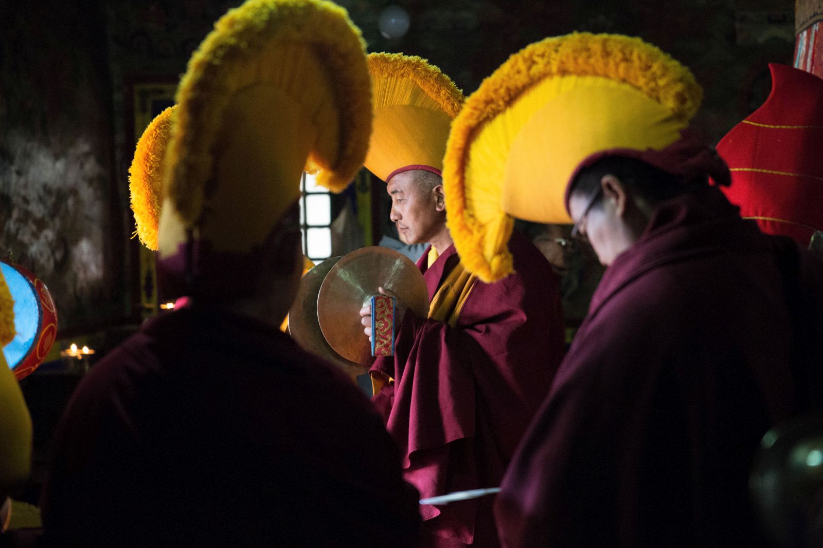 Buddhist monks adorned in vibrant yellow headpieces