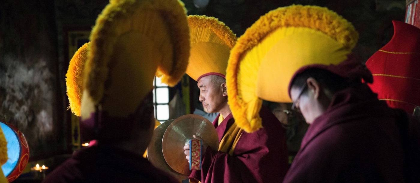Buddhist monks adorned in vibrant yellow headpieces