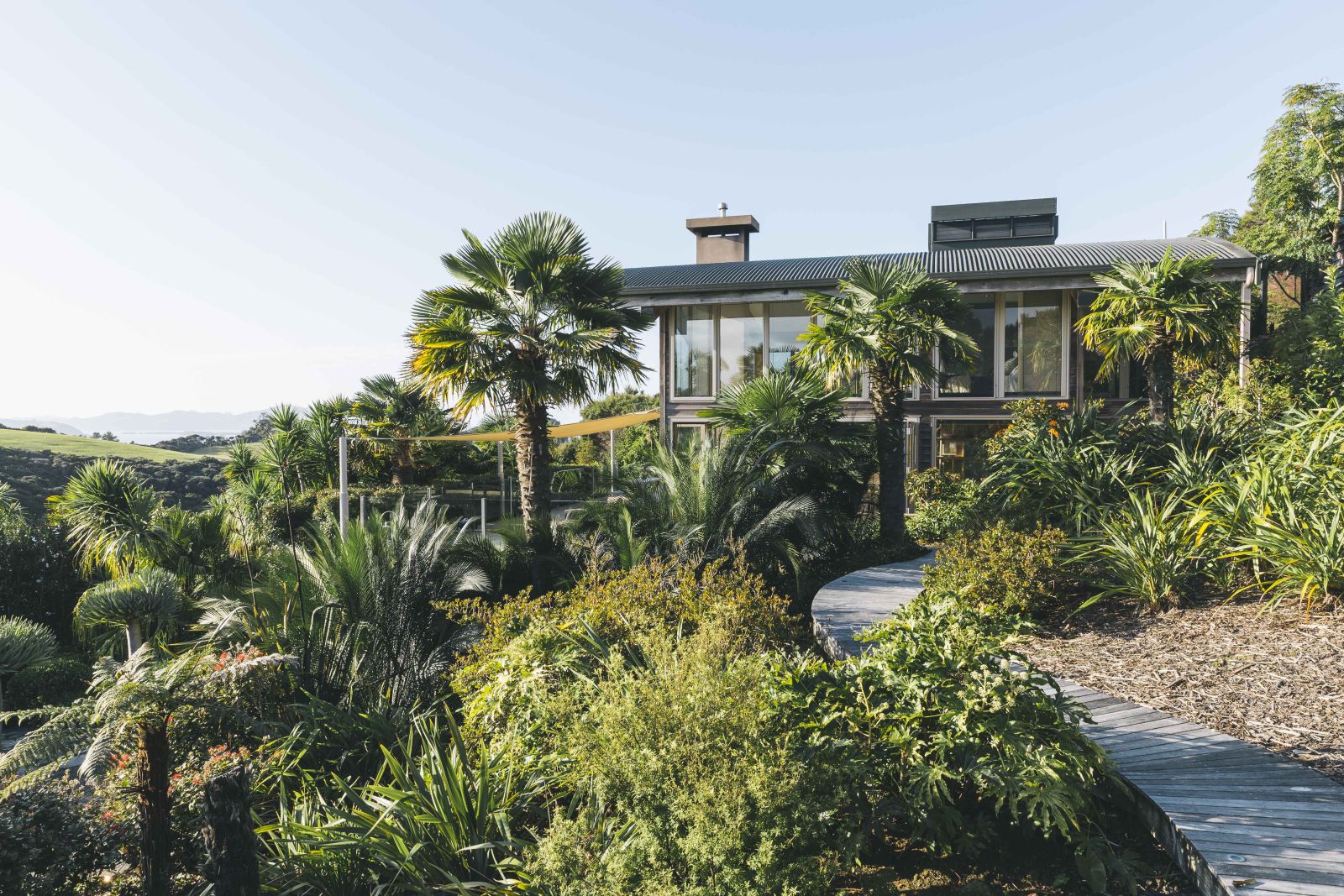 First Light Temple villa New Zealand exterior with native bushes and palm trees