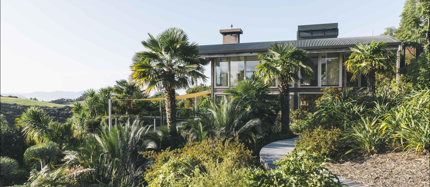 First Light Temple villa New Zealand exterior with native bushes and palm trees