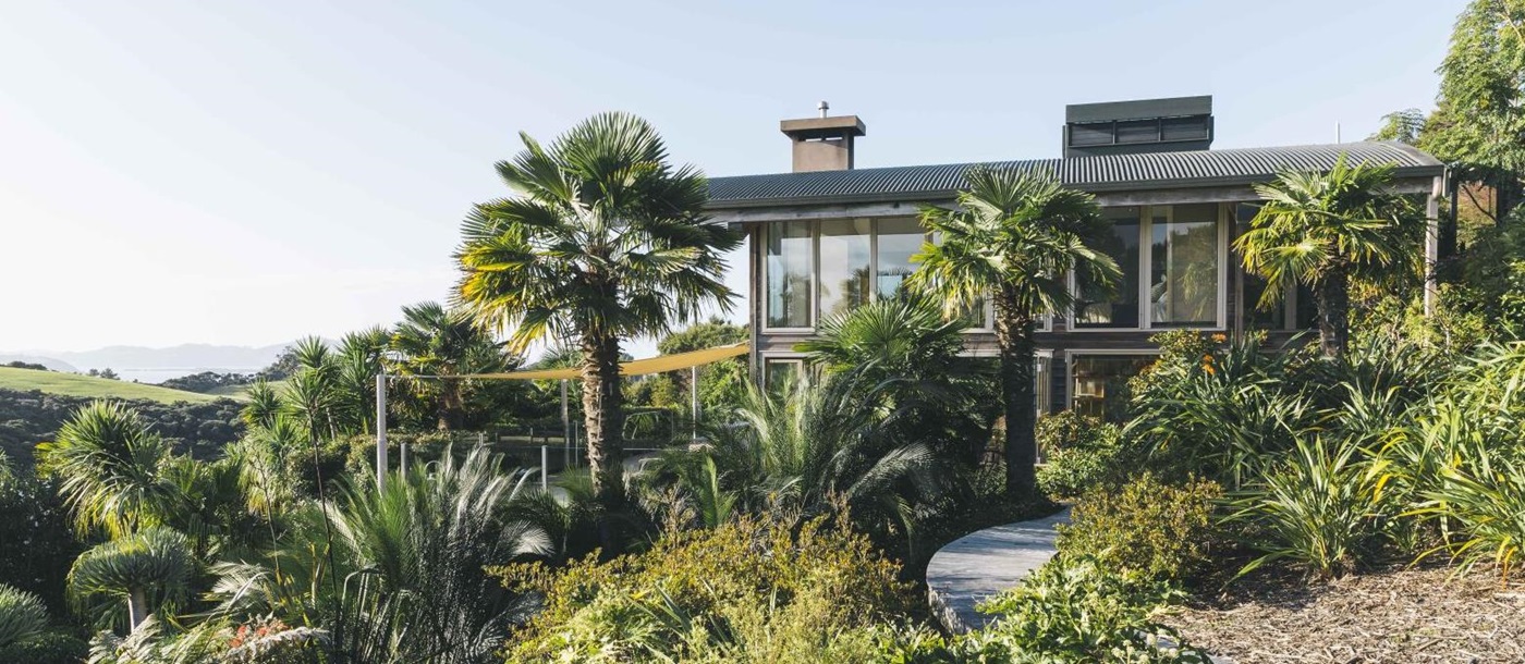 First Light Temple villa New Zealand exterior with native bushes and palm trees