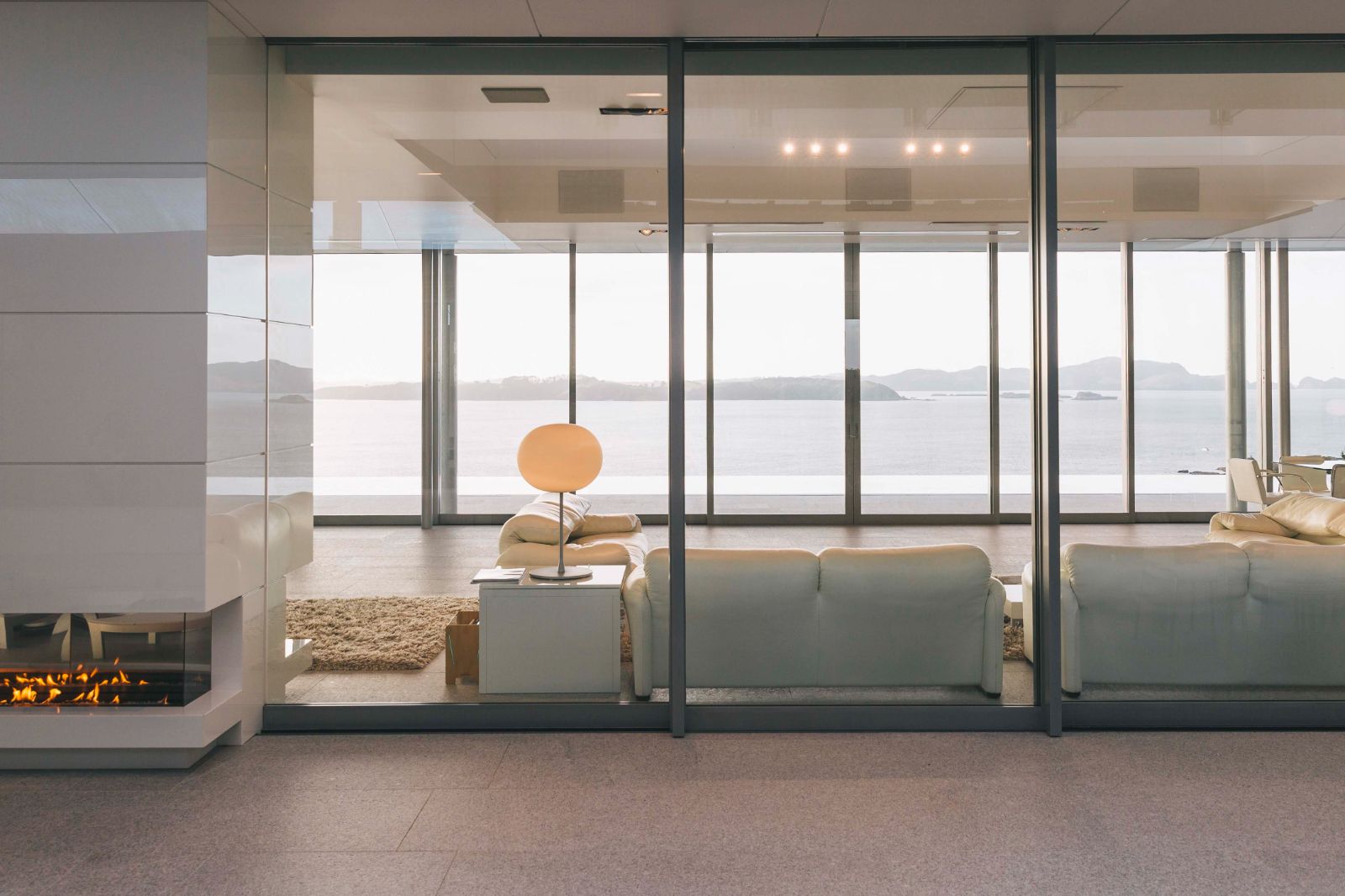 Bright living space with fireplace and floor to ceiling windows at Rahimoana Eagles Nest New Zealand