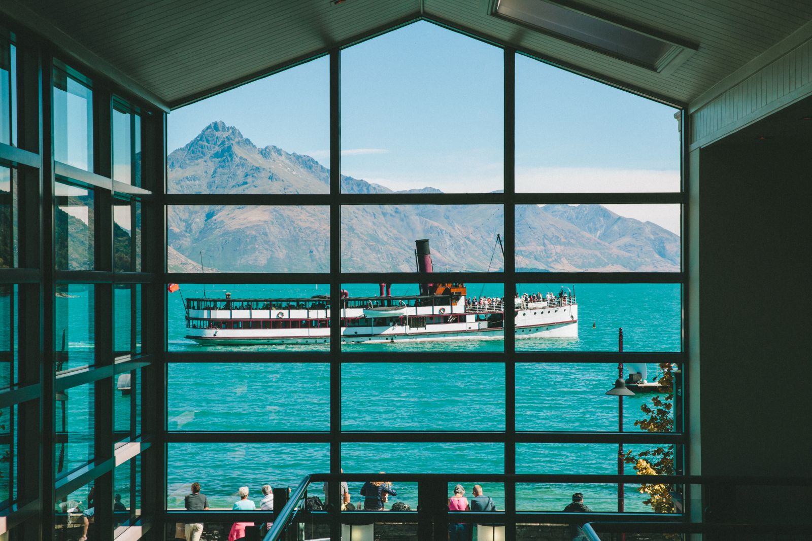 Eichardt's Private Hotel New Zealand restaurant view of the lake with a boat passing by
